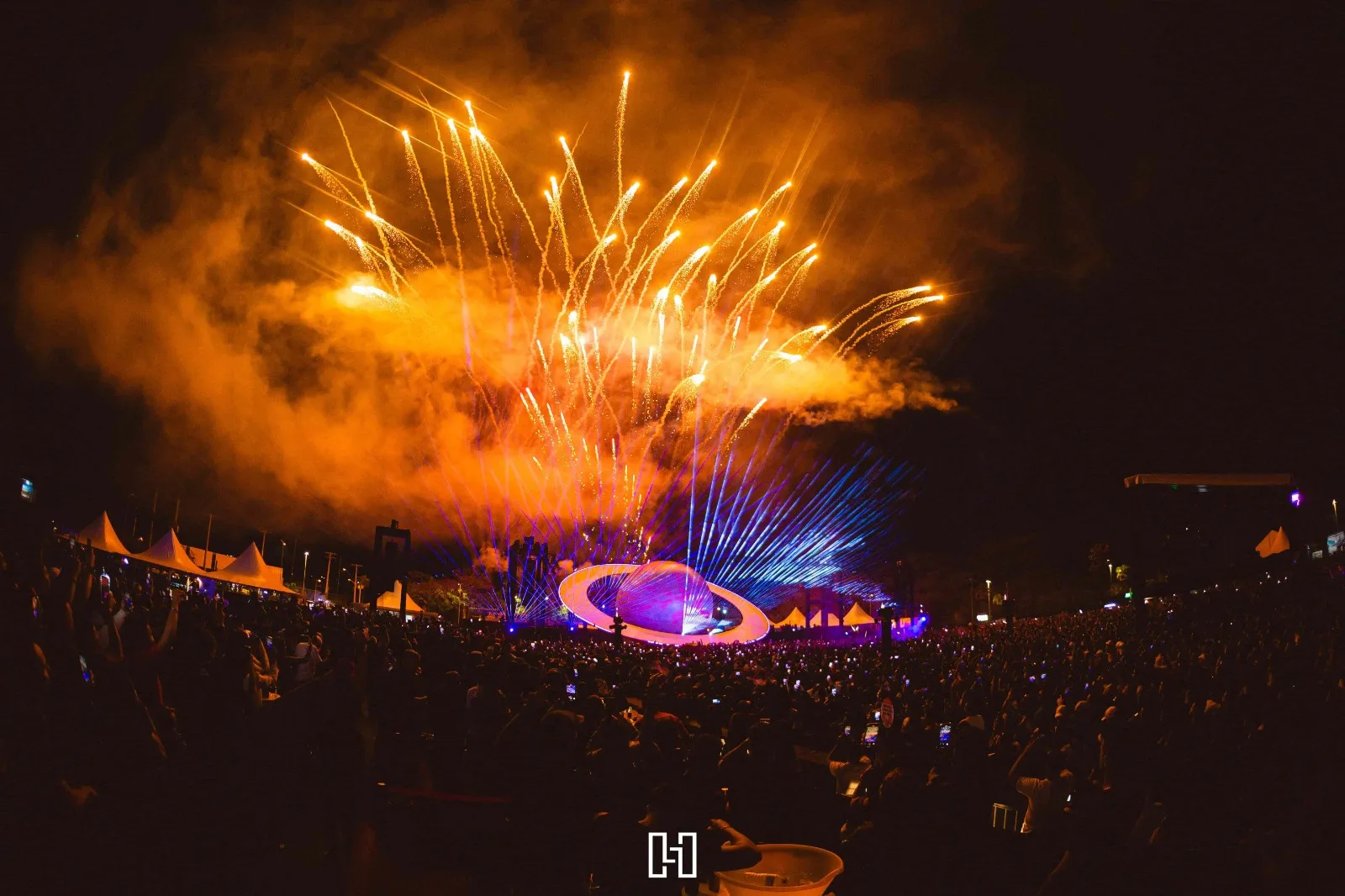 Palco em forma de planeta do Abstract Festival com fogos e lasers abertos sobre o público, à noite