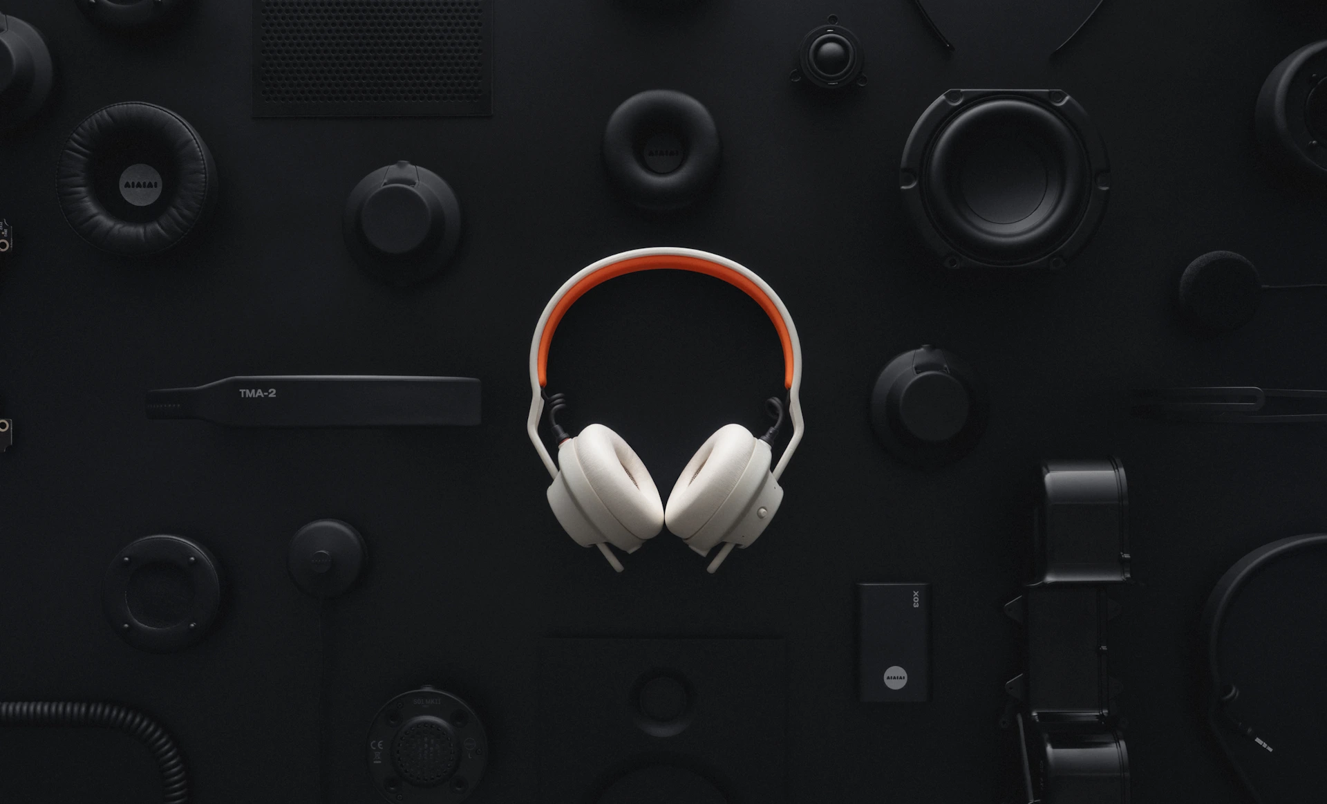AIAIAI TMA-2 DJ Wireless branco cercado pelas peças avulsas da linha TMA-2, sobre fundo preto