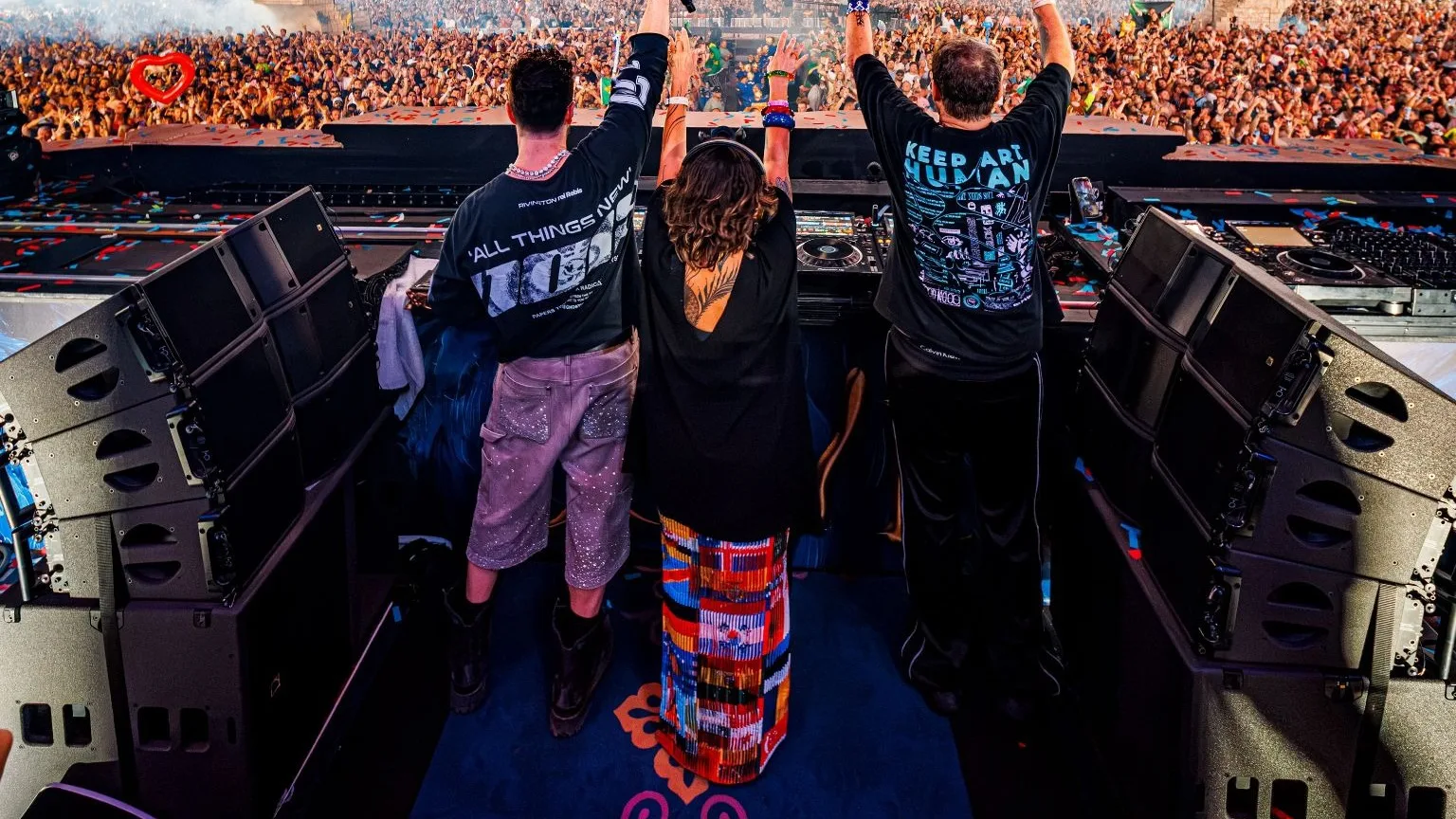 Alok e os pais, Swarup e Ekanta, de braços erguidos na cabine do Mainstage do Tomorrowland diante do público