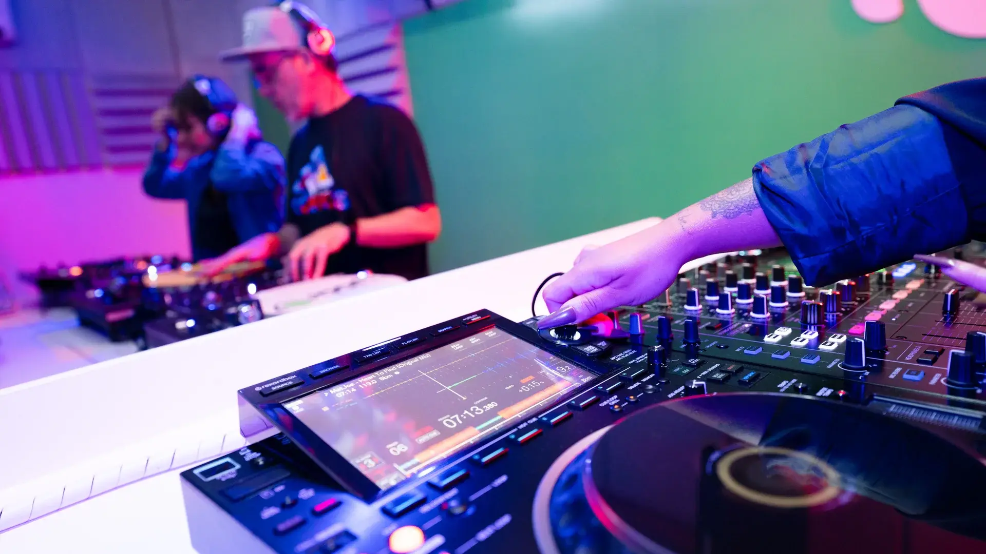 Aluno tocando como DJ no Pioneer DJ CDJ-3000 com iluminação neon · Escola de DJ em São Paulo · DJ Ban EMC